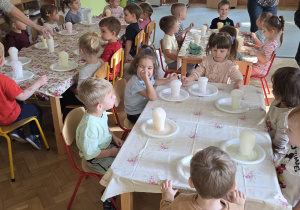 Dzieci obserwują powstający wulkan z połączenia składników chemicznych.