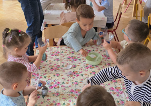 Dzieci wykonują gniotki z wykorzystaniem balonów i kaszy.