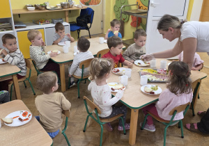 Dzieci jedzą wspólnie śniadanie.