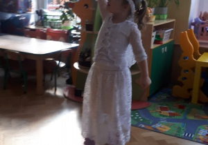 Dziewczynka tańczy w rytm muzyki.