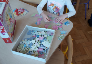 Zabawy wg naszych pomysłów - Julia układa puzzle.