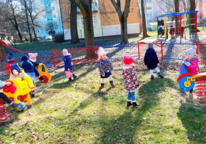 Dzieci podejmują różne formy aktywności ruchowej w ogrodzie.