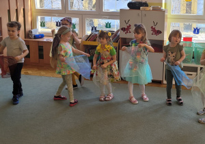 Dzieci tańczą z kolorowymi chustkami.