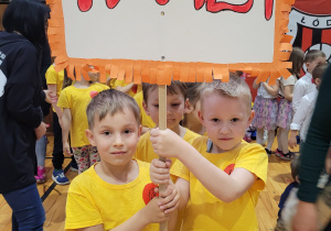 Chłopcy trzymają transparent z numerem naszego przedszkola.