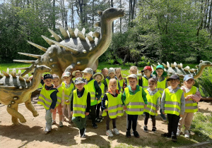 Dzieci stoją przed rodziną dinozaurów.
