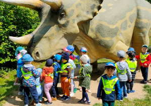 Dzieci oglądają wielkiego Triceratopsa.