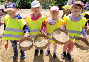 Dzieci prezentują znalezione kości na sitkach.