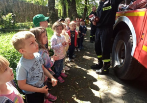 Dzieci oglądają sprzęty używane do gaszenia pożarów.