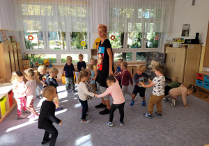 Dzieci tańczą w małych kółeczkach.