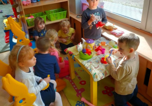 Dzieci bawią się w kąciku lalek- szykują przyjęcie dla gości, na stoliku przygotowane są już pierwsze dania.