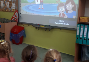Dzieci oglądają film edukacyjny o przedszkolu.