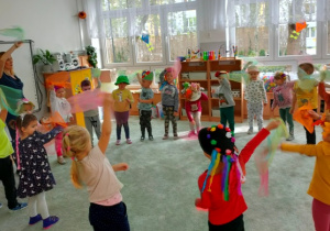 Dzieci stojąc w dużym kole tańczą z chusteczkami w rękach.