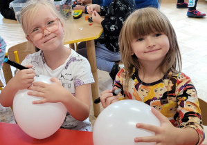 Dziewczynki dekorują balony.