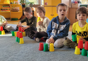 Dzieci układają wieże zgodnie z zapamiętanym wzorem.