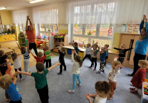 Dzieci rozgrzewają się przed nauką układu tanecznego.