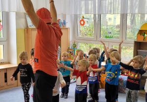 Tata Huga zachęca dzieci do powtarzania tanecznych ruchów.