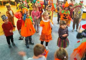 Dzieci tańczą w luźnej gromadce, naśladują ruchy wodzireja.