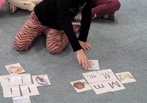 Dziewczynka przyporządkowuje obrazek do danej litery.