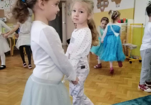 Dziewczynki tańczą w kółeczku.