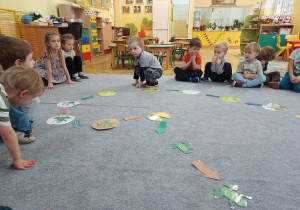 Motylki grają wspólnie w grę planszową na dywanie.