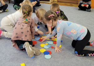 Poznajemy figury geometryczne. Dzieci poszukują kół i kwadratów.
