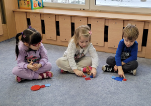 Dzieci przeliczają kolejno ilość ułożonych figur geometrycznych.