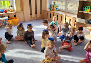 Dzieci ćwiczą wykorzystując woreczek gimnastyczny.