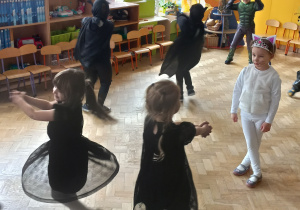 Dzieci w strojach karnawałowych tańczą.