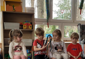 Dzieci po kolei oglądają stetoskop.