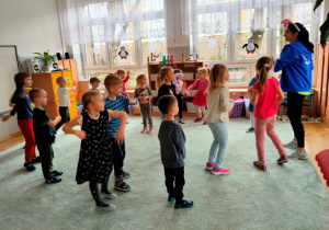 Dzieci odtwarzają prezentowany przez instruktora układ taneczny.