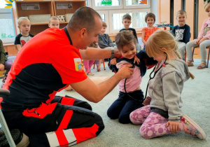 Dzieci za pomocą stetoskopu słuchają bicia serca.