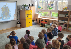 Dzieci oglądają film edukacyjny o Ziemi.