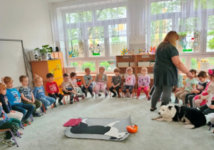 Pani Beata rozdaje wszystkim dzieciom sylwety psa.