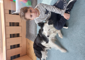Chłopiec siedzi z psem.