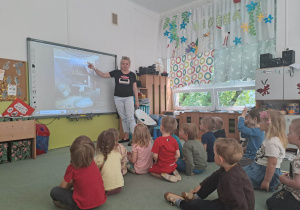 Dzieci oglądają prezentację przedstawiającą aranżację pomieszczenia.