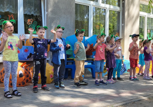 Dzieci zamienione w żabki śpiewają dla innych uczestników zabawy.