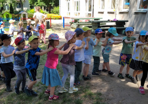 Dzieci tworzą pociąg i tańczą w różnych kierunkach.