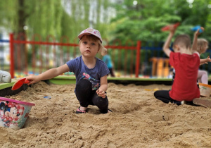 Dziewczynka bawi się w piaskownicy.
