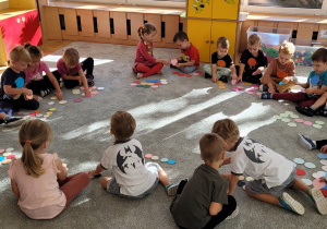 Dzieci tworzą różne kompozycje z kolorowych kropek.