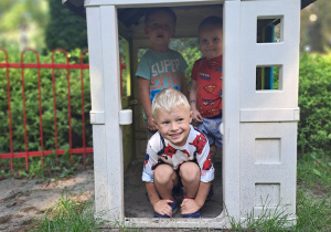 Chłopcy bawią się w domku ogrodowym