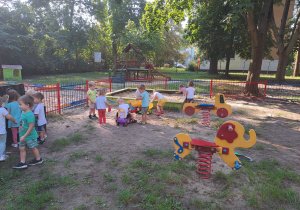 Wszystkie dzieci bawią się w ogródku przedszkolnym