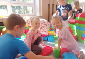 Dzieci budują zamek z mega klocków.