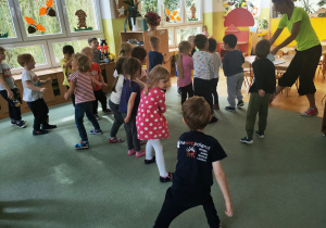 Przy dźwiękach muzyki dzieci odtwarzają prosty układ taneczny.