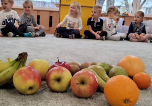 Dzieci po kolei próbują określić zapach i kształt różnych owoców.