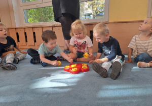 Dzieci chowają przysmaki do zabawki Lili.