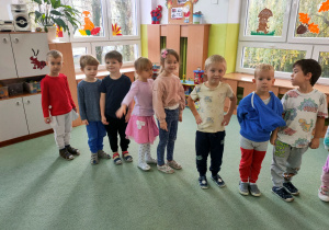 Dzieci stoją jedno obok drugiego- prezentują swój strój założony na lewą stronę.