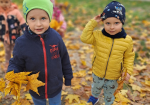 Chłopcy prezentują swoje kolorowe bukiety z liści.