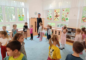 Dzieci słuchają instruktażu Pani Kasi o kolejnych etapach tańca.