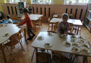 Dzieci rozkładają talerzyki.