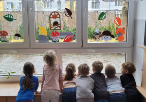 Dzieci wyglądają za okno i opisują pogodę panującą na dworze.